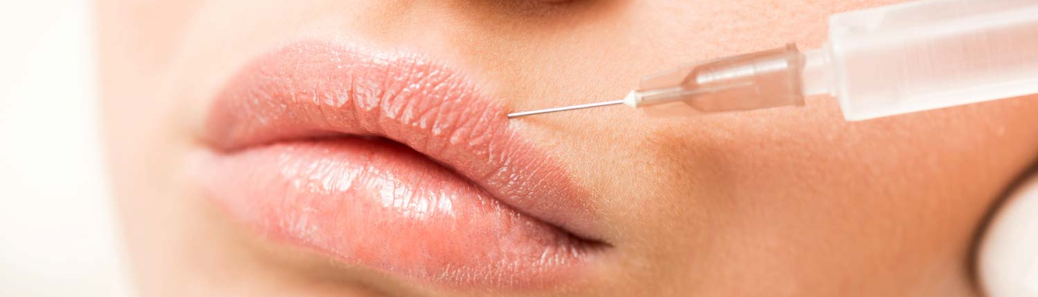 Woman having fillers injected into her lips.